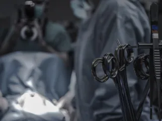 gray surgical scissors near doctors in operating room