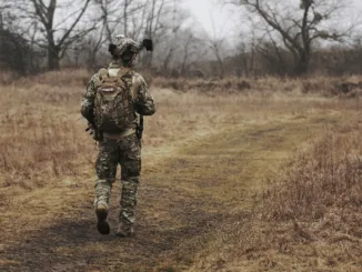 man walking on brown grass field