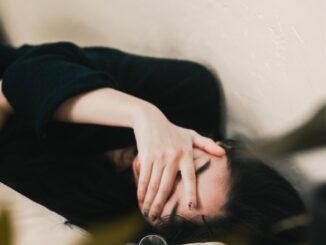 woman in black long sleeve shirt covering her face