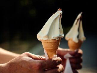 a few hands holding ice cream cones